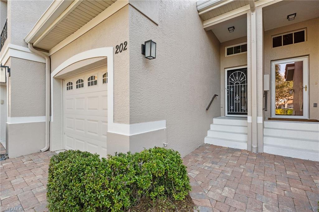1665 Winding Oaks Way, Unit 202 Naples, FL 34109 - Photo 2 of 34 Property entrance featuring stucco siding and a garage