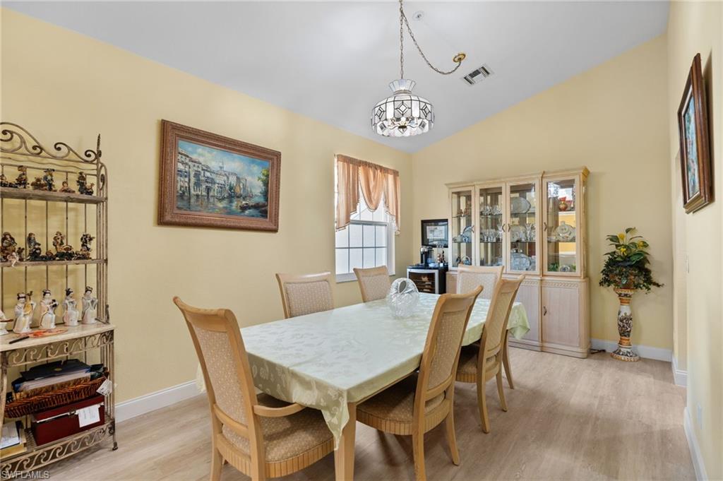 1665 Winding Oaks Way, Unit 202 Naples, FL 34109 - Photo 4 of 34 Dining room featuring light wood-style floors, lofted ceiling, and a chandelier