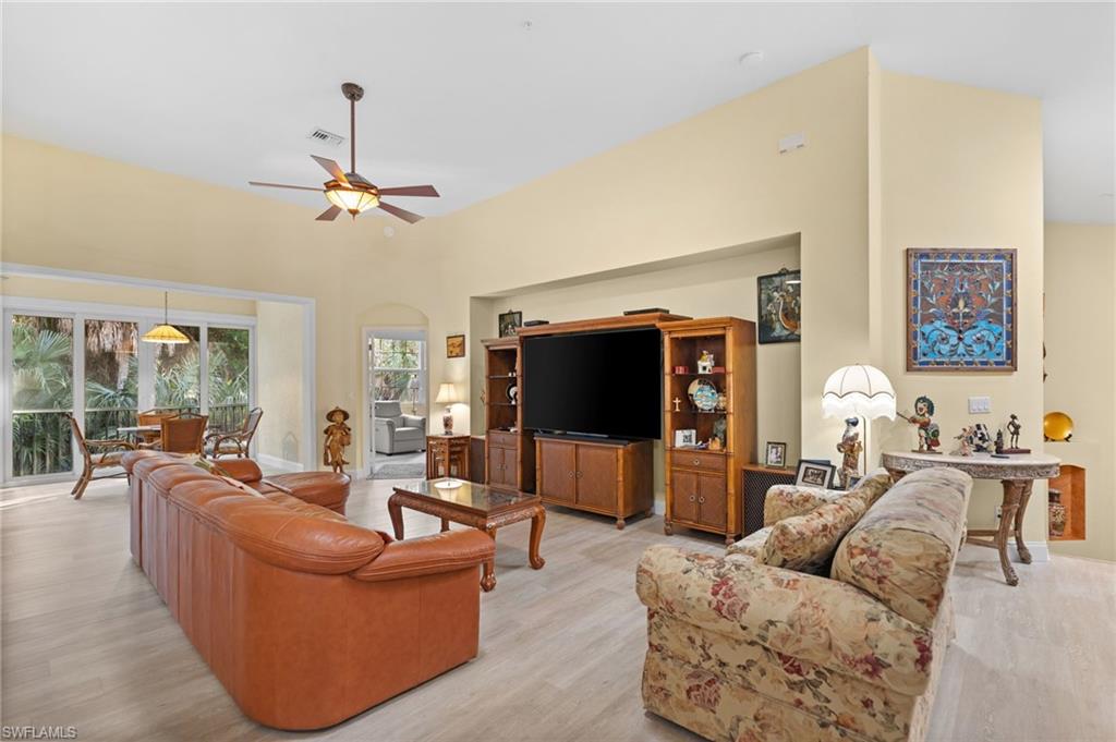 1665 Winding Oaks Way, Unit 202 Naples, FL 34109 - Photo 6 of 34 Living area featuring a high ceiling, ceiling fan, and light wood-style flooring