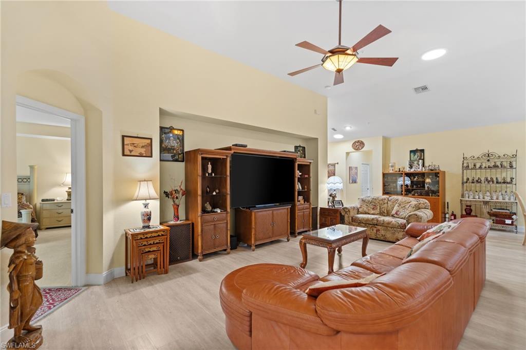 1665 Winding Oaks Way, Unit 202 Naples, FL 34109 - Photo 8 of 34 Living area with ceiling fan, light wood-type flooring, and vaulted ceiling