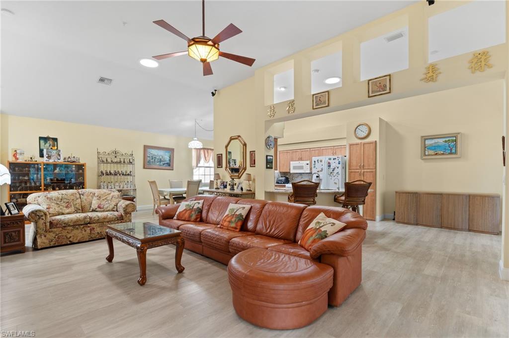 1665 Winding Oaks Way, Unit 202 Naples, FL 34109 - Photo 9 of 34 Living room featuring a ceiling fan, light wood-type flooring, and lofted ceiling