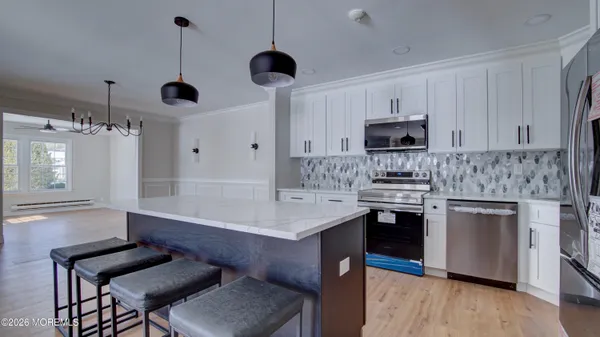 a kitchen with kitchen island a stove cabinets and wooden floor