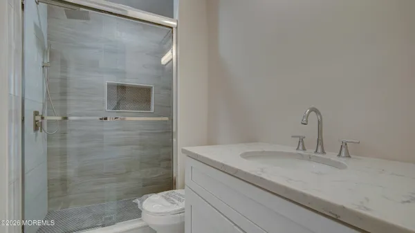 a bathroom with a granite countertop sink toilet and shower