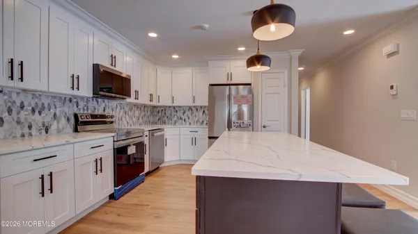 a kitchen with kitchen island a sink stainless steel appliances and cabinets