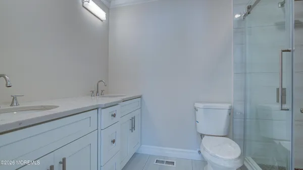 a bathroom with a granite countertop toilet a sink and a mirror