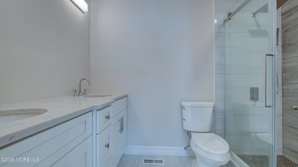a bathroom with a granite countertop sink a toilet and shower