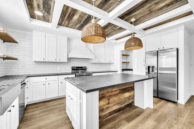 a kitchen with stainless steel appliances granite countertop a sink a stove and a refrigerator