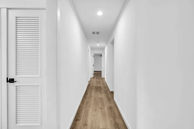 a view of a hallway with wooden floor and staircase