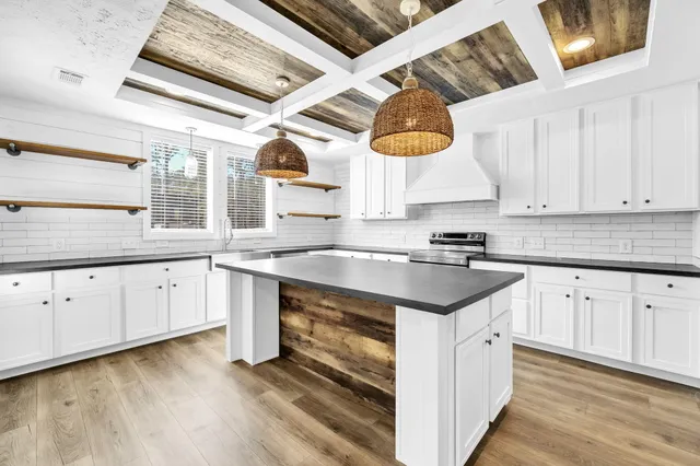 a kitchen with granite countertop a sink cabinets and window