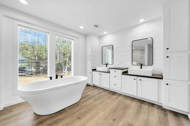 a spacious bathroom with double vanity and a large mirror