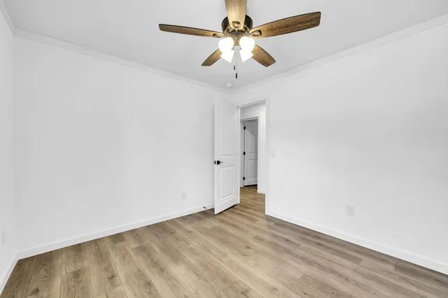 an empty room with a window and a ceiling fan