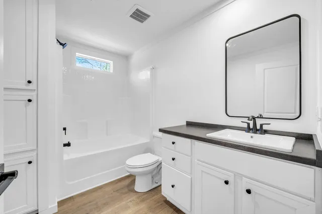a bathroom with a granite countertop sink toilet and shower