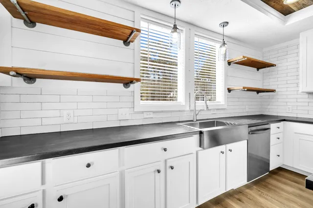 a kitchen with granite countertop white cabinets and white appliances