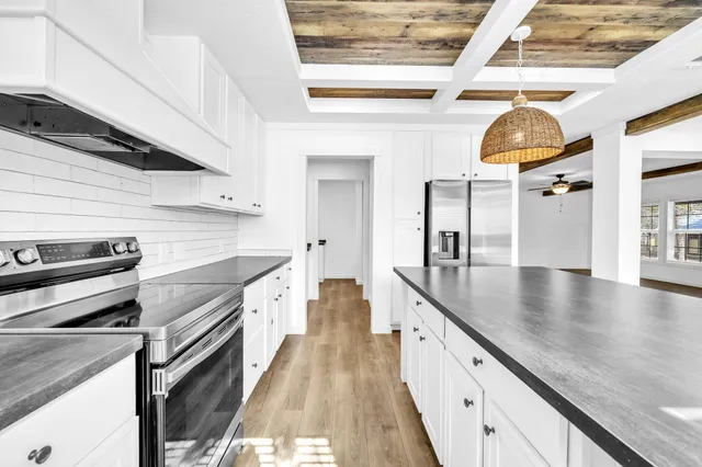 a kitchen with stainless steel appliances granite countertop a sink a stove and cabinets