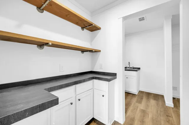 a kitchen with a white cabinets and a wooden floor
