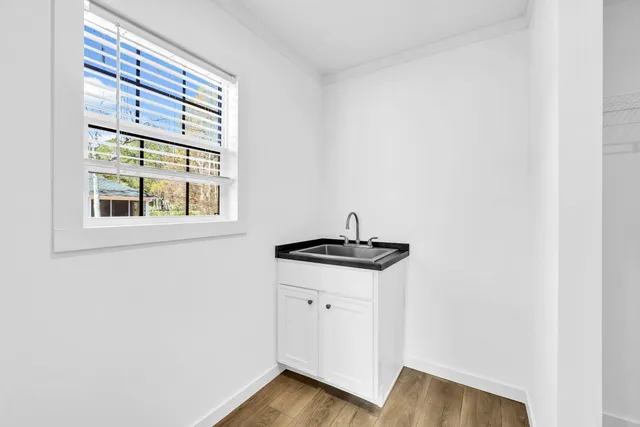 a view of a kitchen with wooden floor and windows