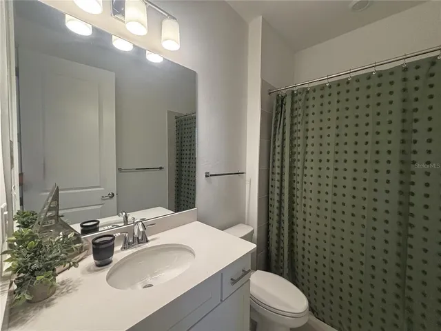 a bathroom with a sink toilet and mirror
