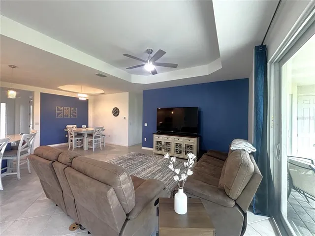 a living room with furniture a flat screen tv and a large window