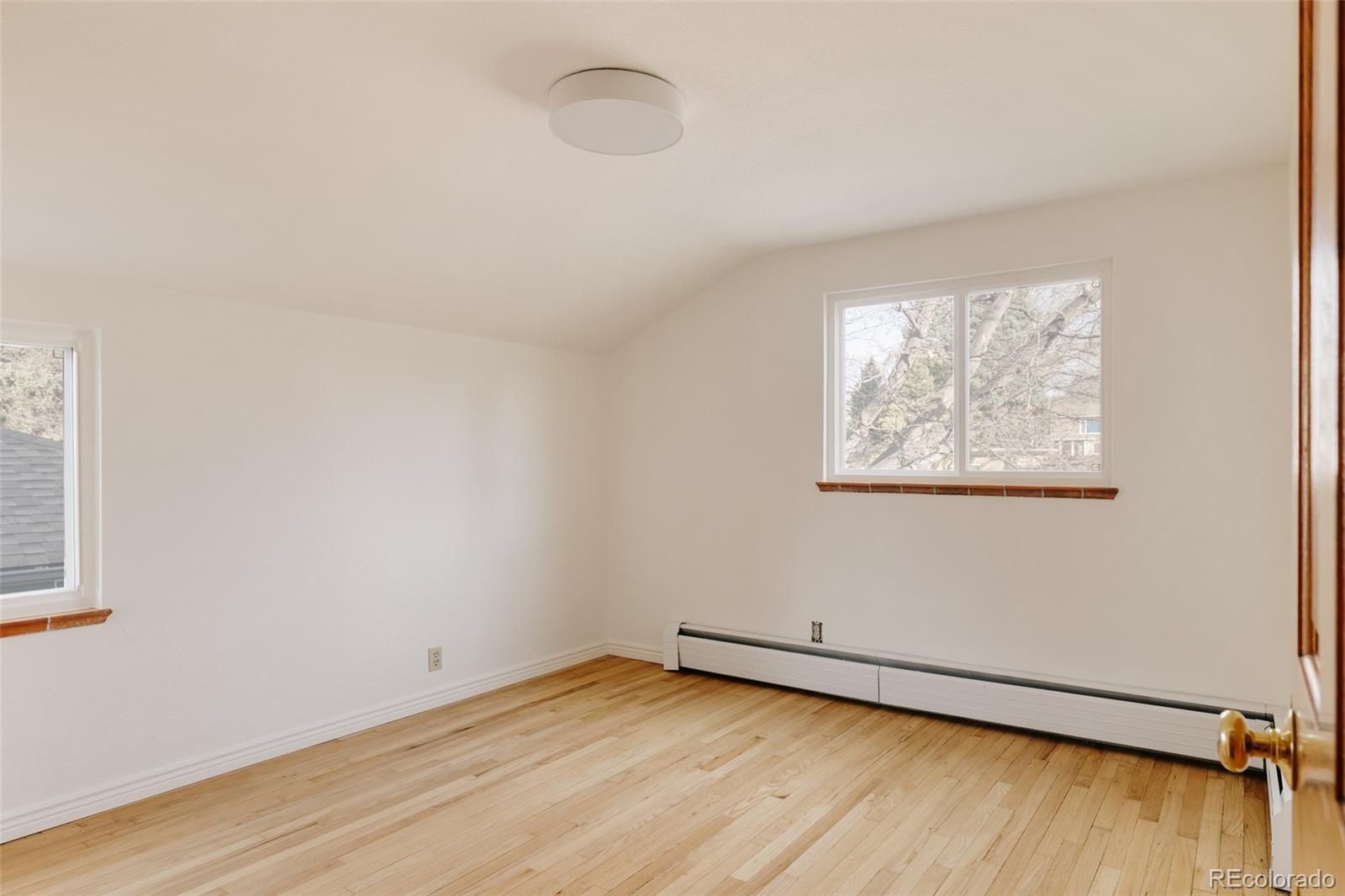 4035 Cody Street Wheat Ridge, CO 80033 - Photo 31 of 47 an empty room with wooden floor and windows