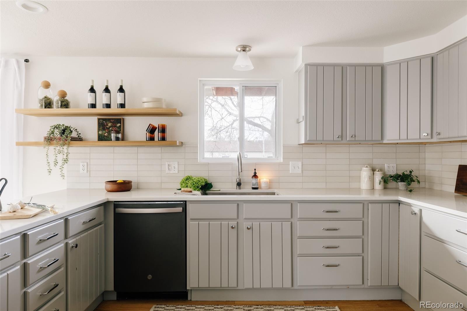 4035 Cody Street Wheat Ridge, CO 80033 - Photo 8 of 47 a kitchen with cabinets appliances a sink and a window