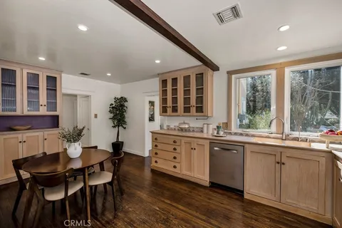 a kitchen with a table chairs sink and cabinets