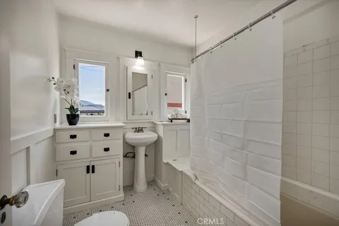 a bathroom with a sink a toilet a mirror and shower