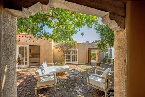 a view of a patio with couches table and chairs and potted plants