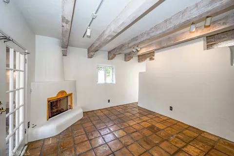 a bedroom with a bed a dresser and potted plants