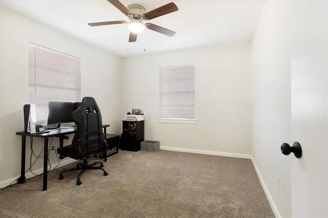 a view of a workspace with furniture and a window