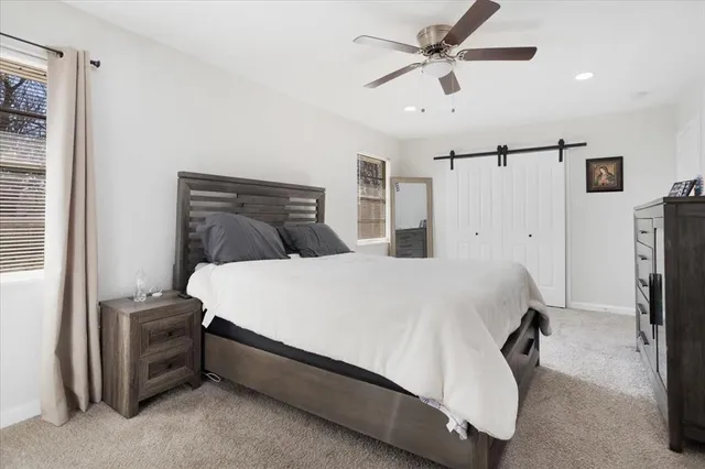 a bedroom with a bed and a ceiling fan