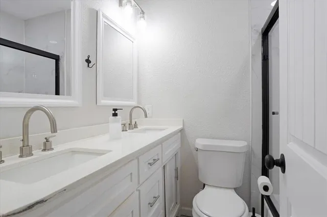 a bathroom with a toilet a sink and mirror