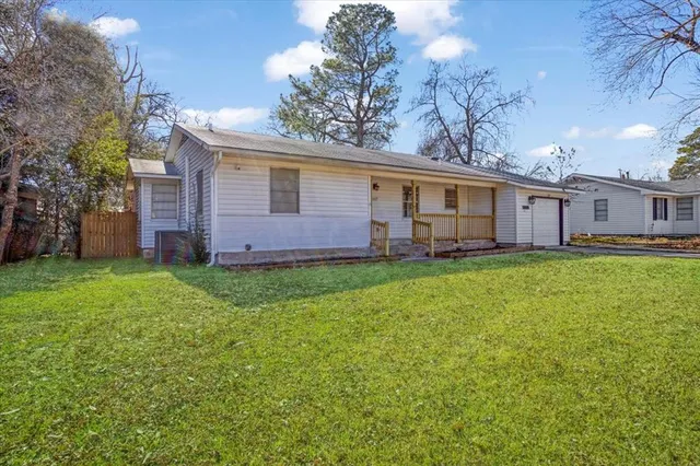 a view of a house with a big yard and large trees