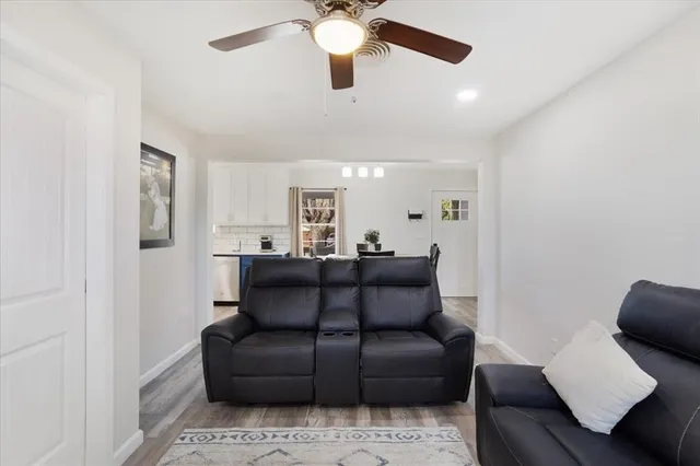 a living room with couches and a ceiling fan
