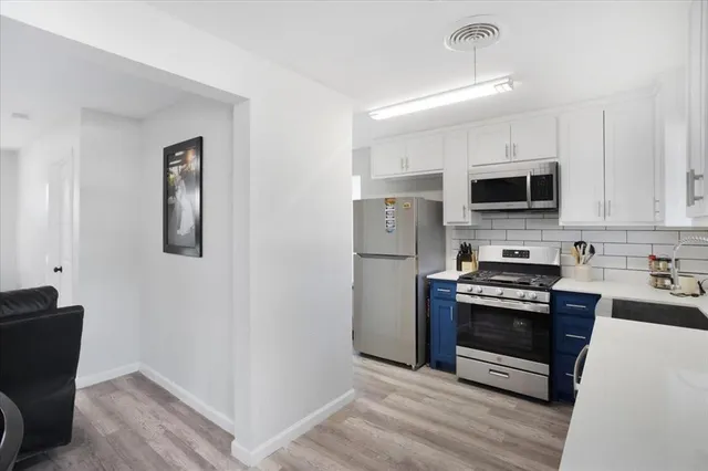 a kitchen with stainless steel appliances a stove microwave and sink