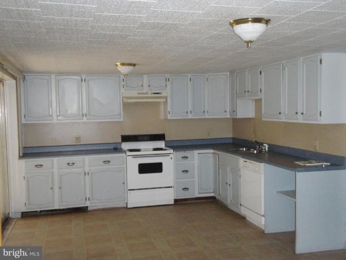 11110 Loop Road Fayetteville, PA 17222 - Photo 3 of 15 a kitchen with granite countertop white cabinets and white appliances