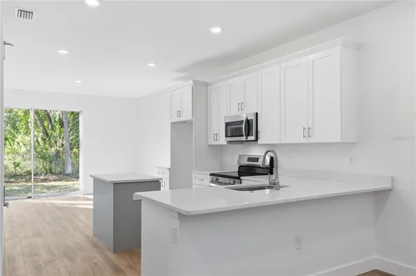 a kitchen with granite countertop white cabinets and a sink