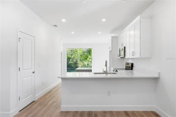a kitchen with stainless steel appliances a sink window and cabinets