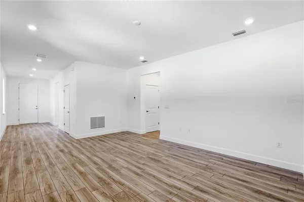 a view of an empty room with wooden floor