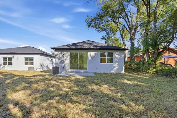 a front view of a house with a garden and tree