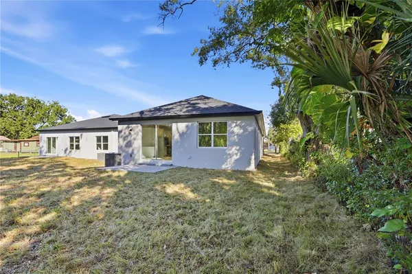 a view of a yard in front of a house with large trees