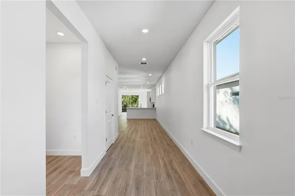 a view of a hallway with wooden floor and windows