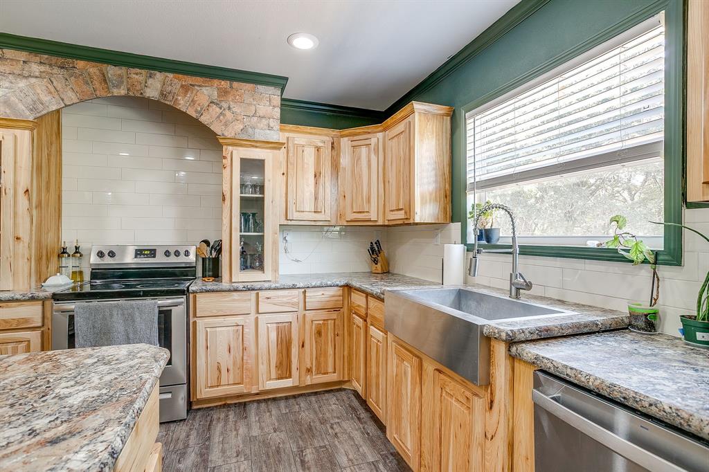 5878 Greenwood Road Millsap, TX 76066 - Photo 19 of 40 a kitchen with a sink stove and cabinets