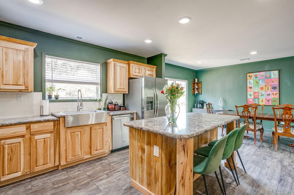 5878 Greenwood Road Millsap, TX 76066 - Photo 2 of 40 a kitchen with stainless steel appliances granite countertop a table chairs sink and window