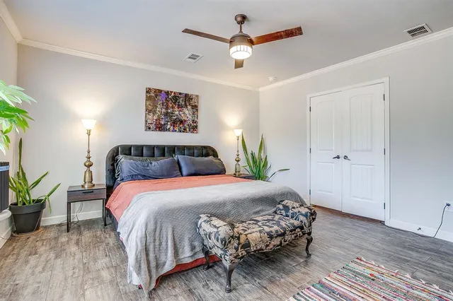 a bedroom with a bed a ceiling fan and a dresser