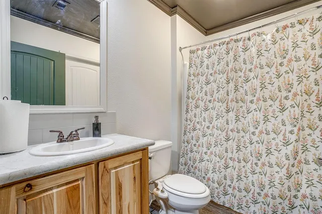a bathroom with a granite countertop sink a toilet and a mirror