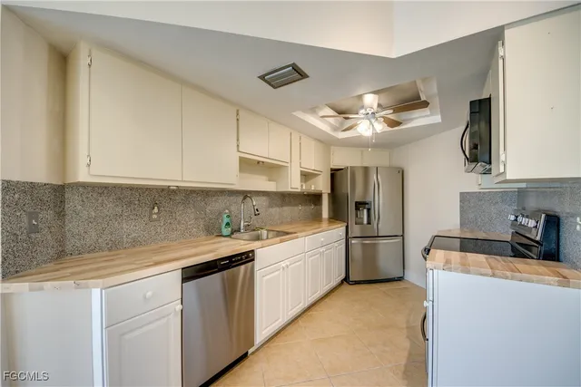 a kitchen with granite countertop a sink and refrigerator