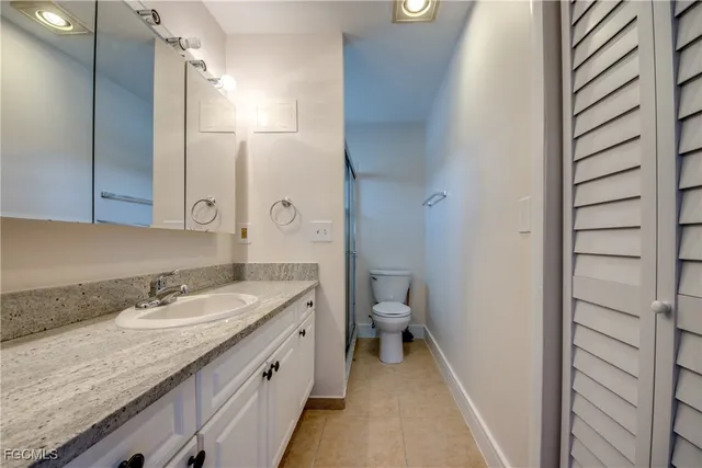 a bathroom with a granite countertop shower and a toilet