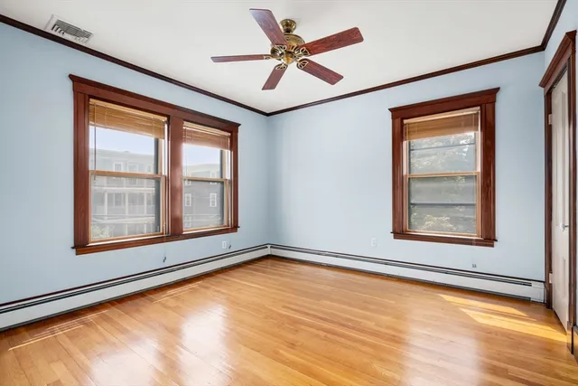 a view of an empty room with a window and a ceiling fan