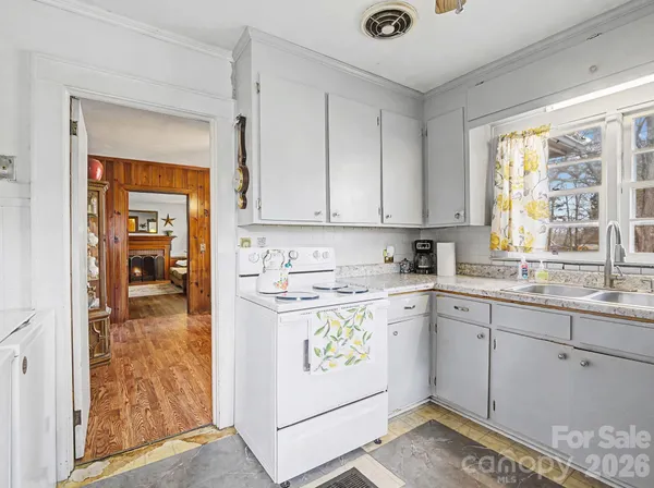 a kitchen with a refrigerator and white cabinets