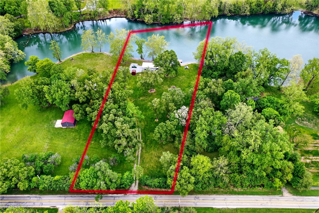 3899 Powell Road Huber Heights, OH 45424 - Photo 1 of 19 This aerial view showcases a vibrant green property bordered by a serene body of water.